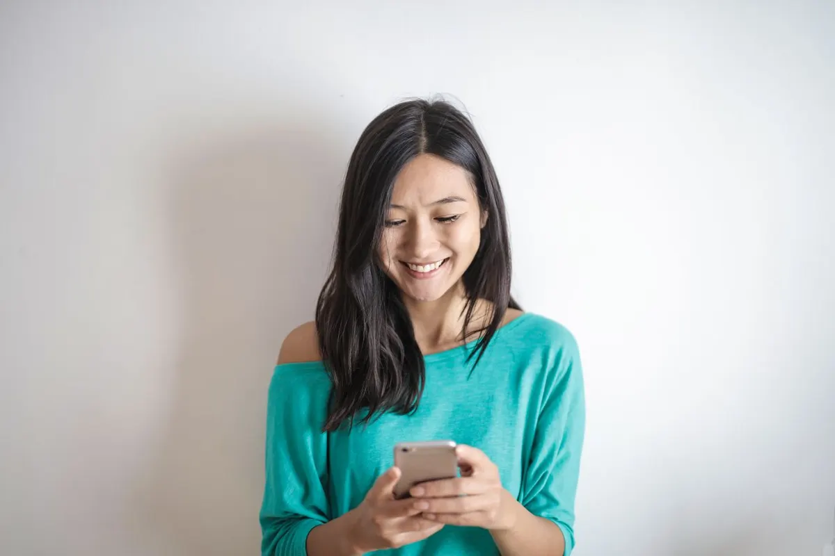 Woman smiling while using her phone