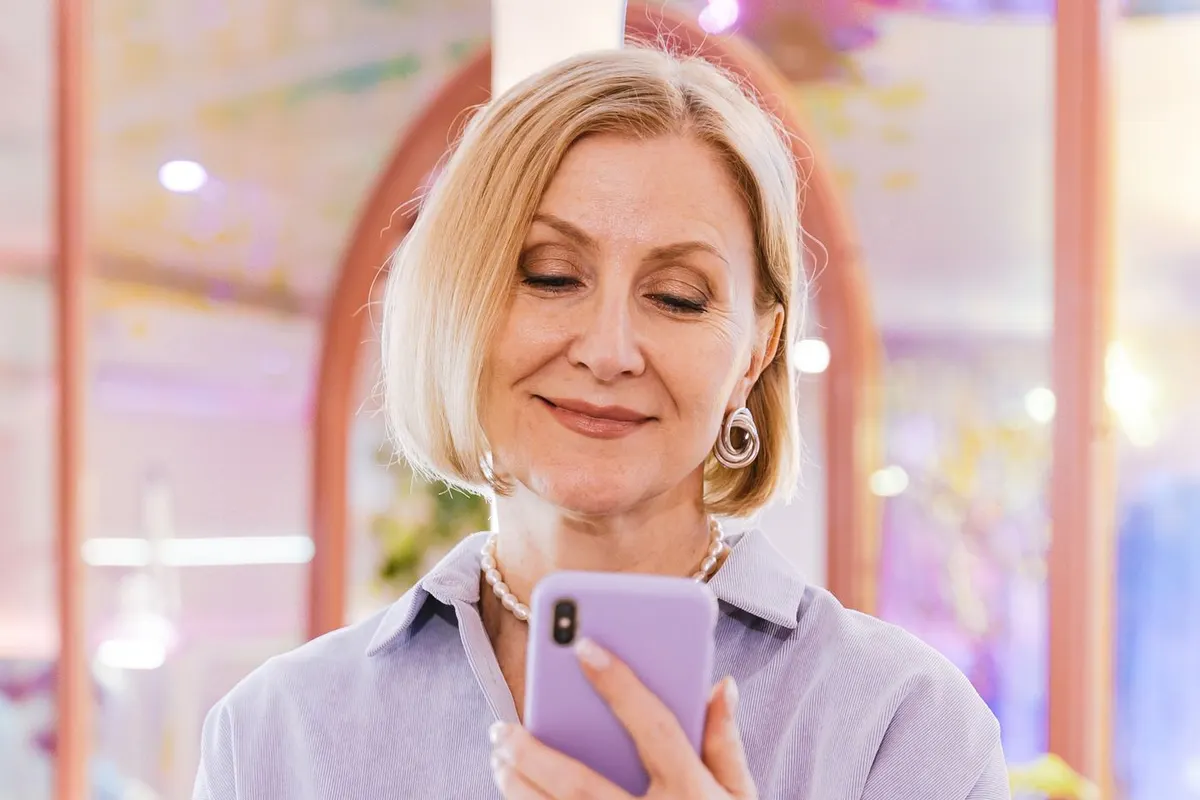Woman smiling while reading a message on her phone